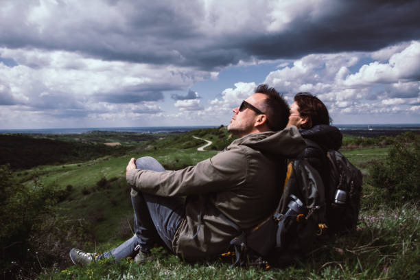 istock Hikers resting on the mountain and looking at the clouds. Storm is coming 1150576572