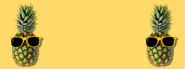 istock Fresh pineapples with sunglasses on yellow background. Creative suumer concept. 1150576662