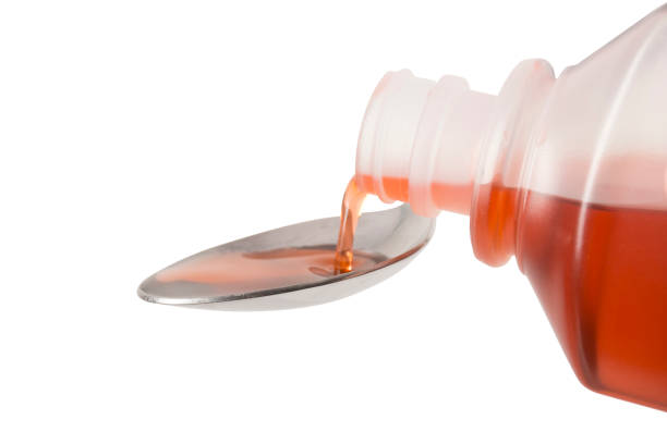 red cough medicine being poured onto a spoon - cough medicine spoon medicine tablespoon imagens e fotografias de stock