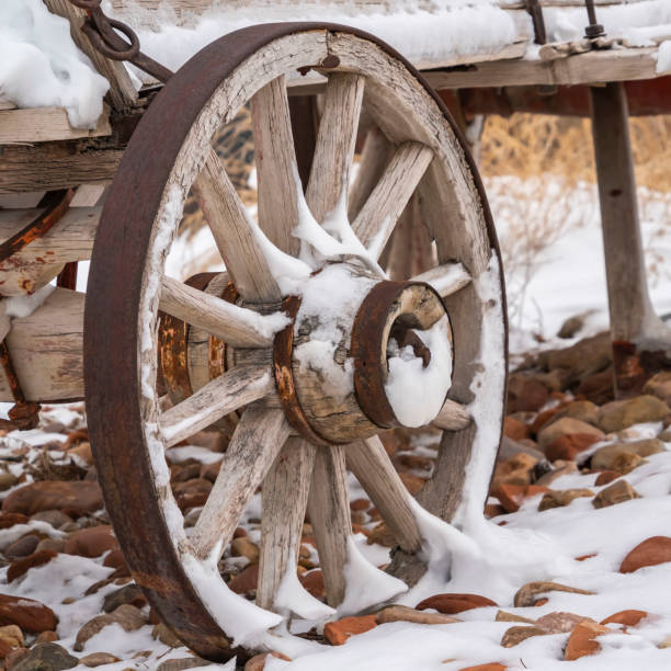 istock Square An old wooden wagon with rusty wheels dusted with snow in winter 1150582220