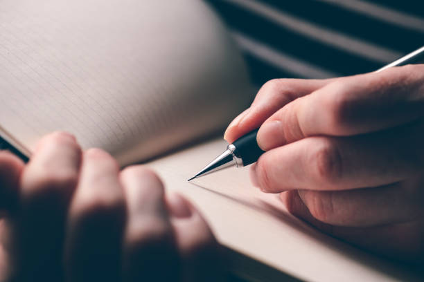 Left-handed woman writing diary, close up