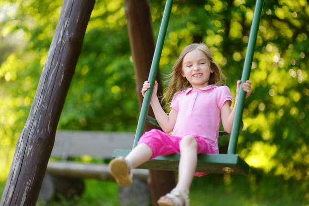 istock Adorable girl having fun on a swing 1150584097