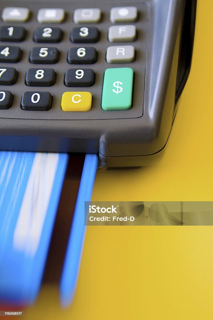 Credit Card Terminal (01) A credit card terminal on a golden yellow background, with credit card insertion (motion blur). Dollar sign on the green button. Focus on the slot. Blue Stock Photo