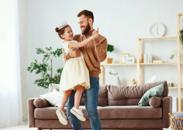 Happy father's day! family dad and child daughter Princess dancing at home