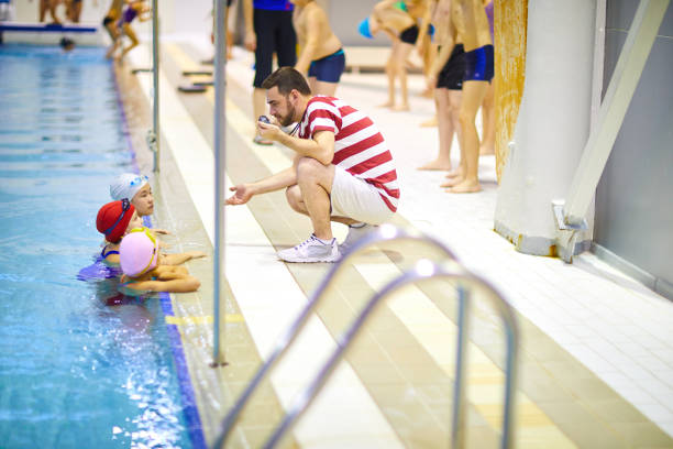 istock Swimming lesson with trainer in pool 1150590313