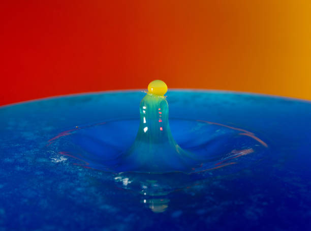 Droplet photography: a yellow drop falling into the blue water