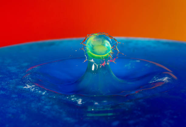 istock Droplet photography: a yellow drop falling into the blue water 1150590405