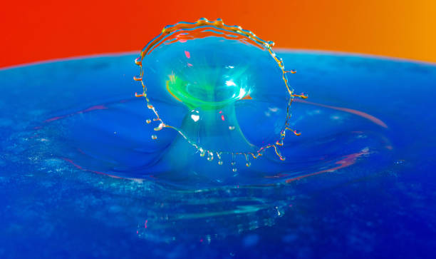 istock Droplet photography: a yellow drop falling into the blue water 1150590416