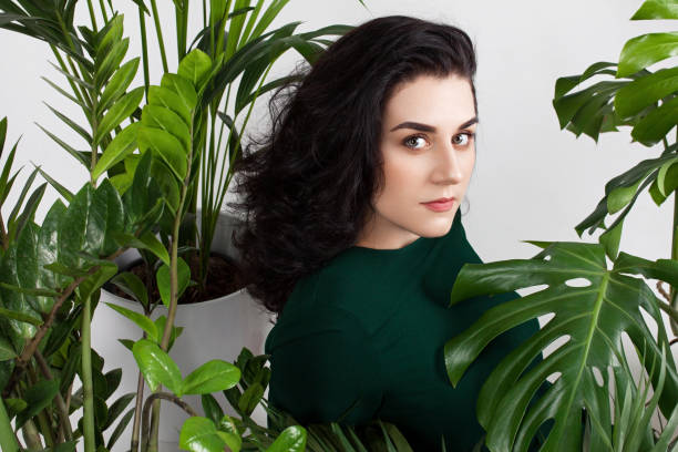 istock Young attractive woman siting between large home plants. 1150591588