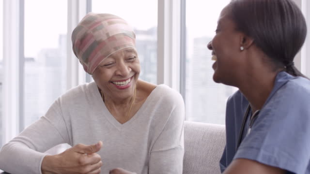 Senior woman with cancer reviews test results with female doctor