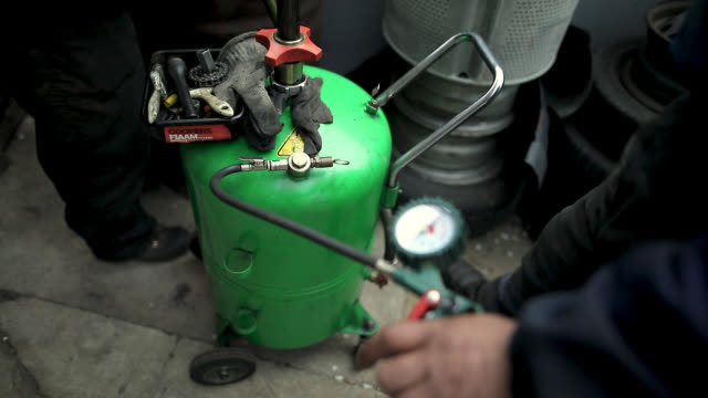 Man using gas compressor behind garage