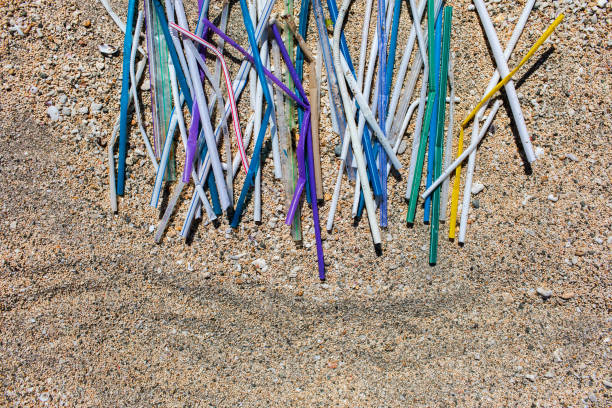 istock Heap of different multicolor plastic straws collected on the beach on sand background 1150597207