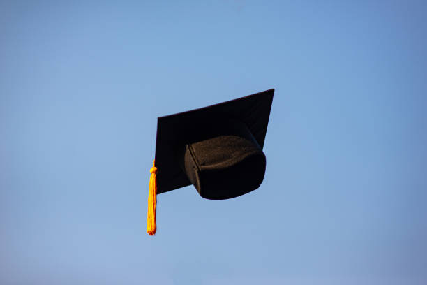 istock Throw a black hat of graduates in the sky. 1150604952