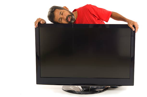 Tired man hugging the tv on white background .