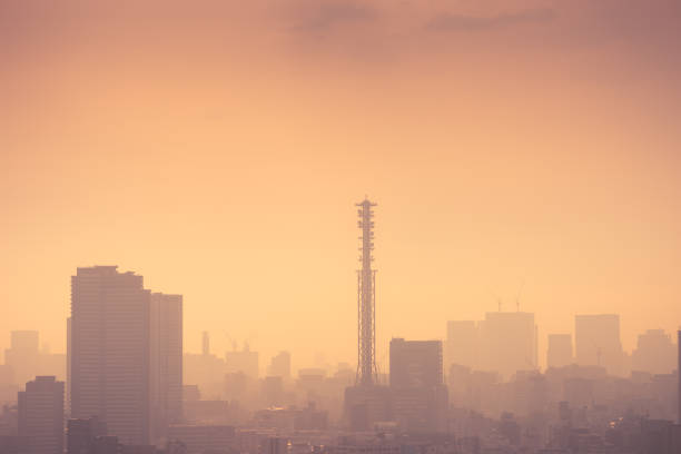 Smog filled Shinjuku Tokyo, Japan skyline The sun is rising over the urban scene in the morning. The image was taken from a tall building to get this high vantage point. The Sky West Tokyo tower in Nishitokyo, can be seen in the distance. dystopia concept photos stock pictures, royalty-free photos & images