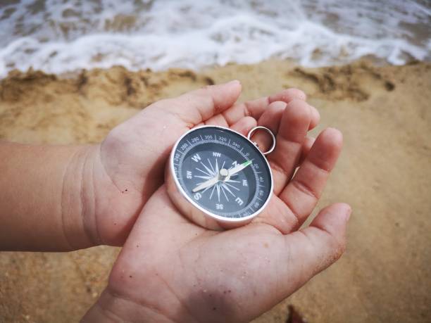istock A young boy holding on a compass pointed to the north facing to the ocean. 1150641457