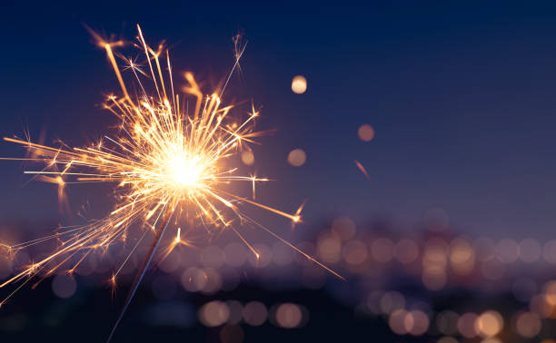 sparkler con fondo de luz borrosa ciudad, feliz año nuevo - sparkler fotografías e imágenes de stock