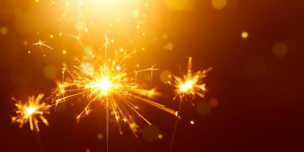 istock Glittering burning sparkler against golden bokeh background 1150644518