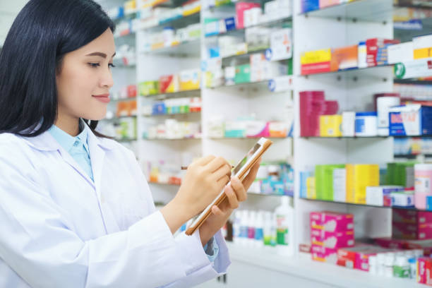 istock Pharmacist working with a tablet computer in the pharmacy holding it in her hand while reading information 1150644627
