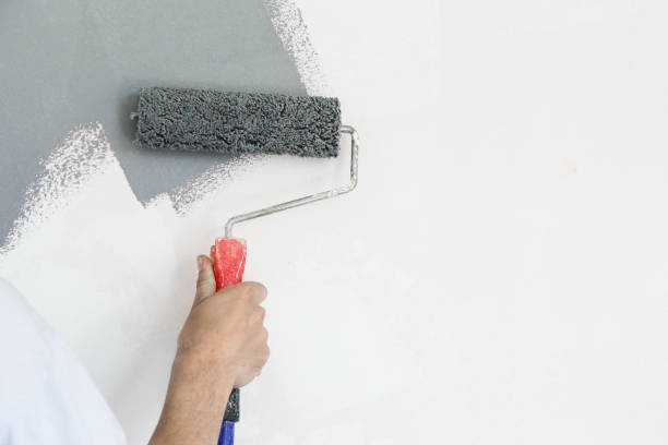istock Paint roller. Painting with gray paint over a white wall 1150649015