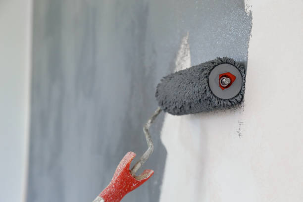 istock Paint roller. Painting with gray paint over a white wall 1150649514