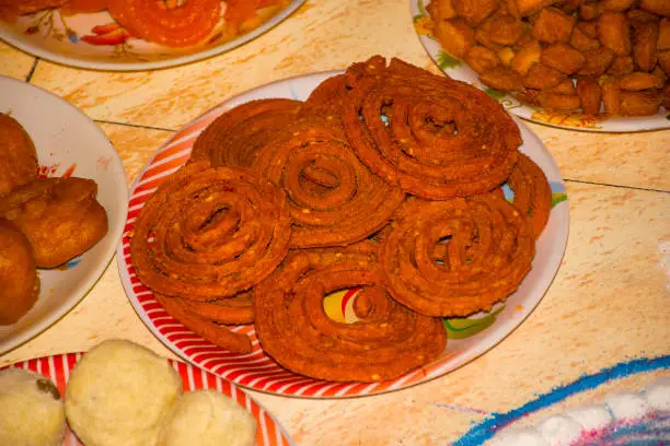 Photo of Indian snack - chakli. Spiral shaped, pretzel-like snack with a spiked surface. Chakli is typically made from flours of rice, bengal gram and black gram