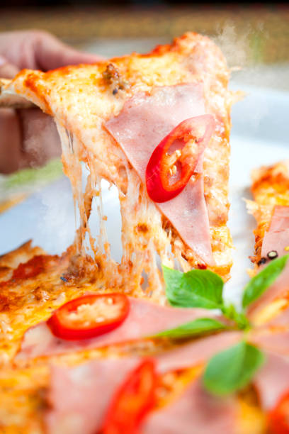 Pizza with meat sauce topped with seafood With paprika, delicious vegetables, fast food, traditional Italian delicacies, Close up Italian pizza about cheese it stick. Selective focus.
