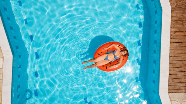 istock Woman in bikini sunbathing on watermelon inflatable ring 1150653943