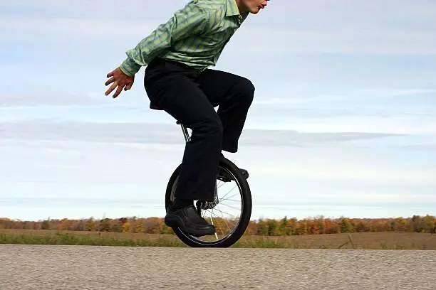smartly dressed young man on unicycle