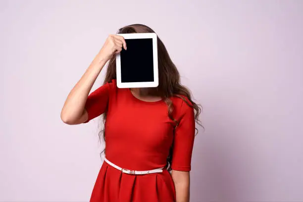 Girl with tablet. Red dress. Modern technologies.