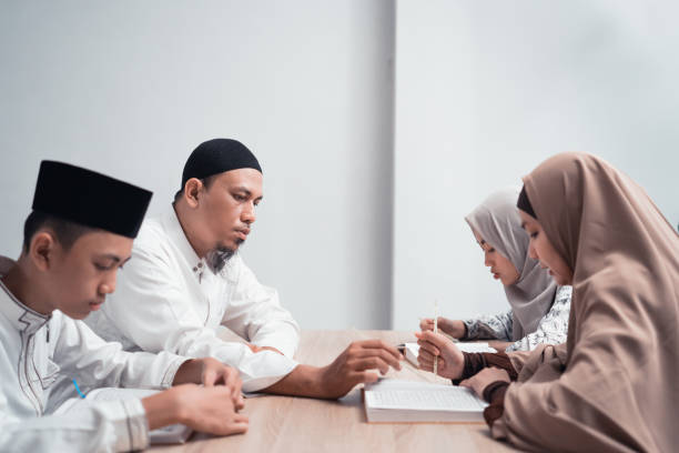 muslim family reading quran or holy book of islam together portrait of happy muslim family reading quran or holy book of islam together father allah stock pictures, royalty-free photos & images
