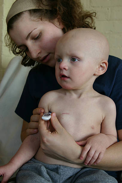 A baby with cancer having its temperature taken stock photo