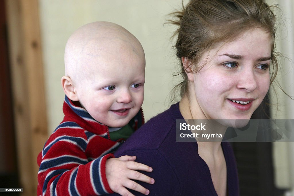 Cancer Kids; baby getting piggyback ride care-giver and child with cancer Cancer - Illness Stock Photo