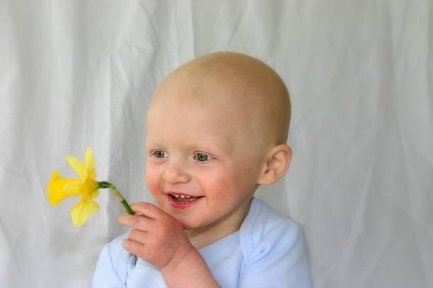 close-up of happy bald child with daffodil (to all who have shown interest; our little guy is now 4 years old and CANCER FREE! :) )