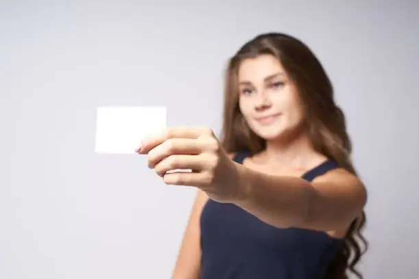 White card. Portrait girl. Blurred background. Arm.