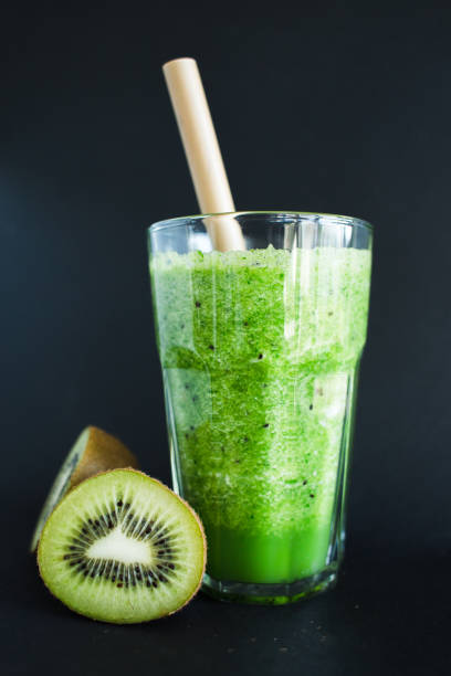 istock Healthy green smoothie in a glass cup on a black background 1150655902