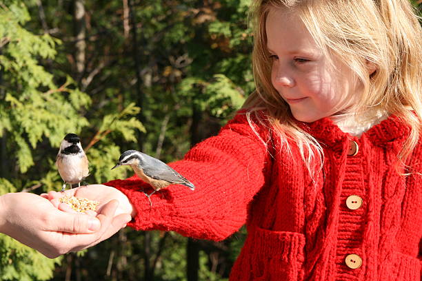 mom helps little girl in red sweater