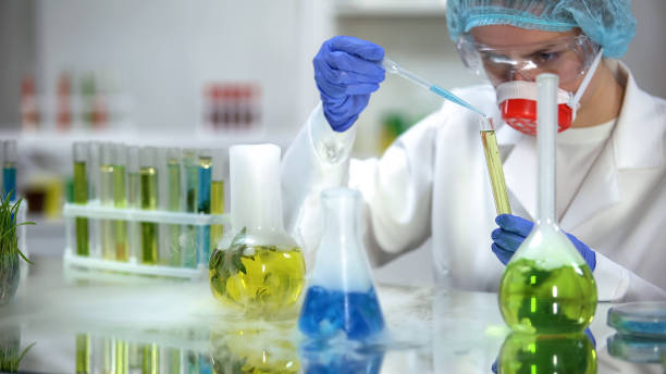 istock Chemist adding blue liquid in tube with yellow oily substance observing reaction 1150660740
