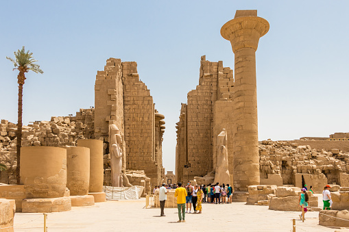 Abu Simbel, Egypt - November 14, 2018 :  \nthe guardian of the Nefertari's temple of Hathor keeps watch at the entrance of the temple and takes advantage of this moment of tranquility to talk on cell phone