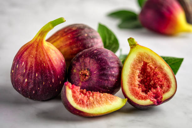 istock Half and whole figs on gray cement or stone background. 1150661105