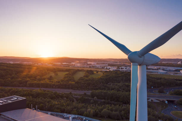 schöner sonnenuntergang hinter wind turbine in sheffield, east yorkshire, großbritannien vor bäumen und gebäuden-frühjahr 2019 - wind turbine wind turbine yorkshire stock-fotos und bilder