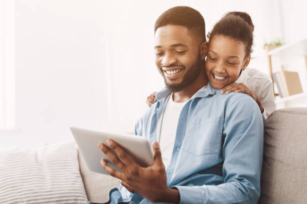 istock Father and daughter having video call on tablet 1150663386