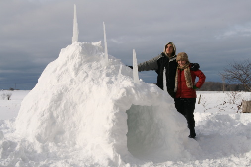 Young couple outside a snow fort.