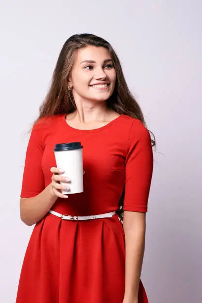 Girl with coffee. Red dress. White glass.