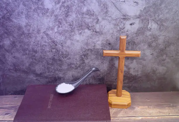 Photo of holy bible and sea salt with stand wood cross for background and inspiration