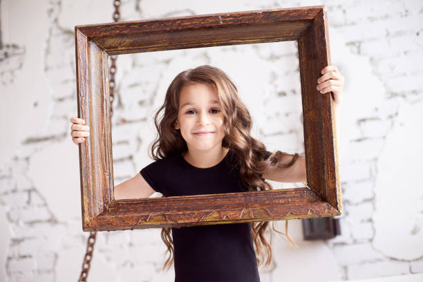 istock Portrait girl. Wooden frame. Light background 1150665527