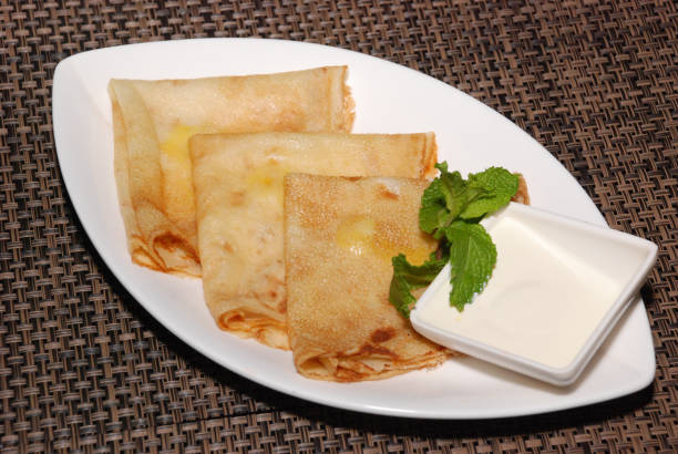istock russian pancakes with sour cream on the white plate 1150665756