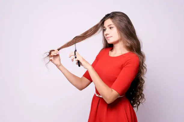 Girl hairdresser. Long hair. Red dress. Black shears.