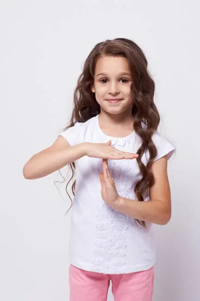 Little girl. Stop gesture. White background.