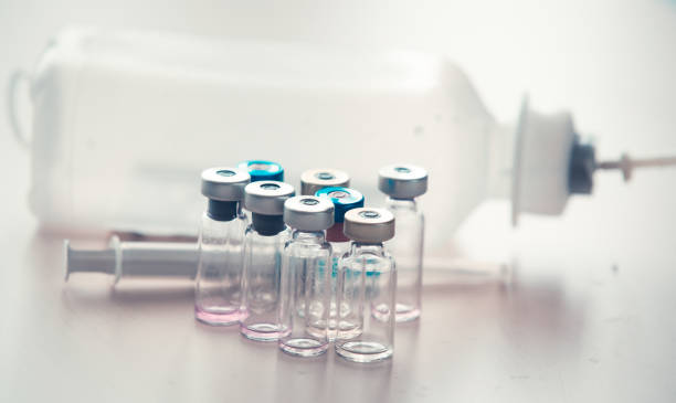 istock Medical background with  syringe and vaccine bottles 1150669497